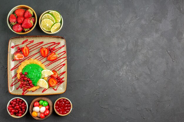 Top view delicious cake with candies and fruits