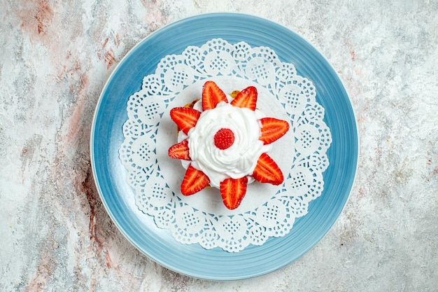 Vista dall'alto deliziosa torta con panna e fragole su spazio bianco