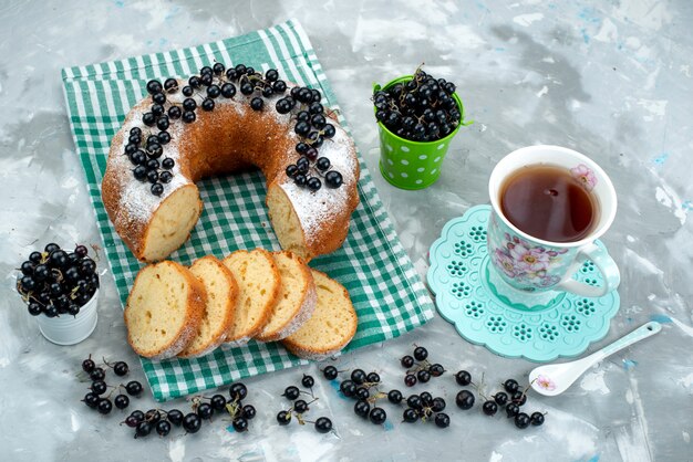 Вид сверху вкусный торт со свежей черникой и чаем на белом столе торт бисквитный чай ягодный сахар