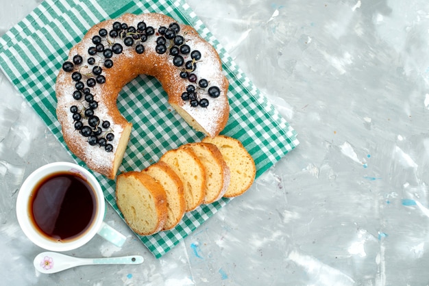 A top view delicious cake with fresh blueberries and tea on the white desk cake tea berry