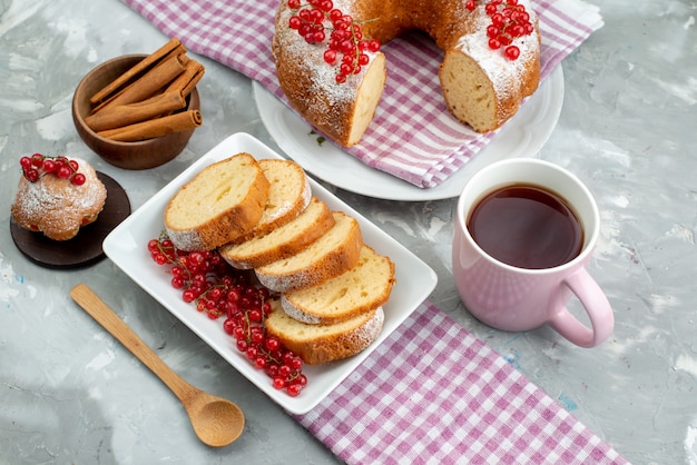 白いデスクケーキビスケットティーベリーシュガーの上の新鮮な赤いクランベリーと平面図おいしいケーキ