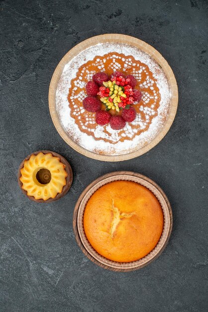 Top view delicious cake with raspberries and round pie on grey background cake pie fruit berry sweet cookie