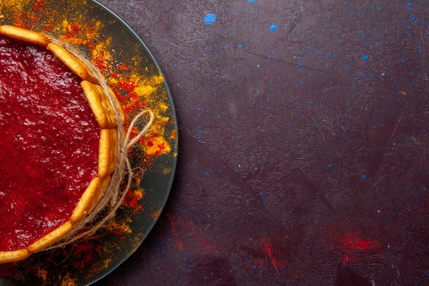 Top view delicious cake with red cream and cookies on dark background biscuit cake sugar dessert pie sweet cookie