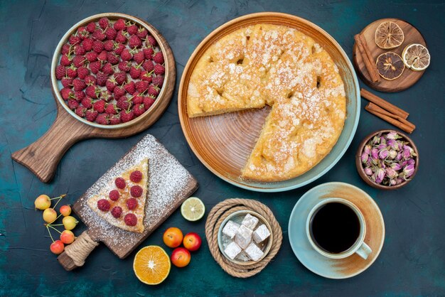 Top view delicious cake with tea and fruits on the dark blue desk pie cake sweet biscuit sugar