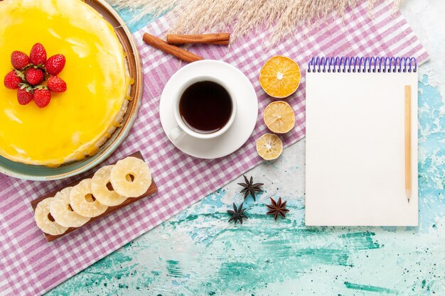 Top view delicious cake with yellow syrup and cup of tea on light-blue background biscuit cake sweet pie cookies sugar tea