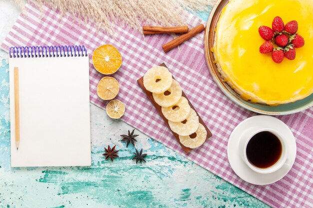 Top view delicious cake with yellow syrup and cup of tea on light blue surface biscuit cake sweet pie cookies sugar tea