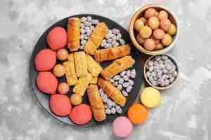 Free photo top view delicious cakes with bagels crackers candies on light-white desk cake biscuit cookie sweet sugar pie