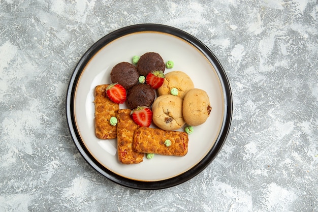 Top view delicious cakes with cookies and strawberries on white surface biscuit sugar cake sweet pie tea cookie