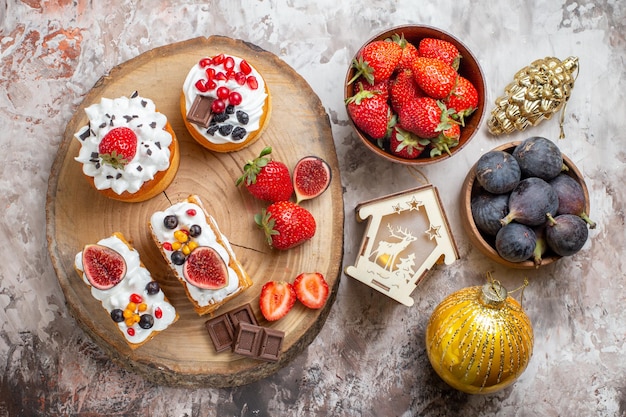 Top view delicious cakes with fresh fruits on light floor