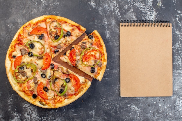 Foto gratuita vista dall'alto deliziosa pizza al formaggio affettata e servita su una superficie grigia