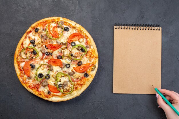 Вид сверху вкусной сырной пиццы с оливками, перцем и помидорами на темной поверхности