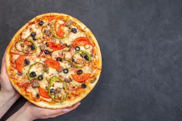 Вид сверху вкусной сырной пиццы с оливками, перцем и помидорами на темной поверхности