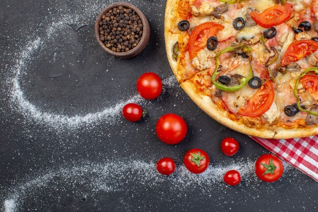 Top view delicious cheese pizza with red tomatoes on dark background