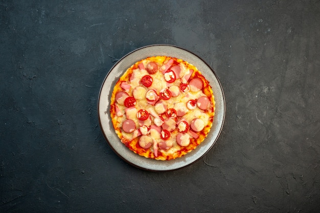 トップビュー暗い背景にソーセージとトマトのおいしいチーズピザイタリア料理生地ケーキファーストフード写真の色