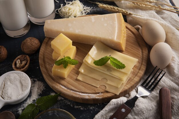 Top view of a delicious cheese platter with milk, flour, and eggs on a table