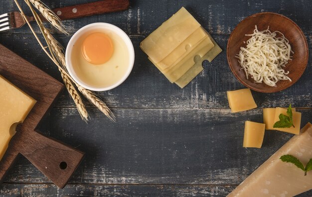 コピースペースのあるテーブルの上にクルミ、卵、小麦粉が入ったおいしいチーズの盛り合わせの上面図