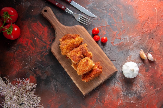무료 사진 토마토 어두운 표면이 있는 커팅 보드에 있는 맛있는 닭 날개