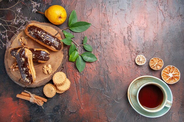 어두운 테이블 디저트 달콤한 케이크에 차 한잔과 함께 상위 뷰 맛있는 초코 eclairs