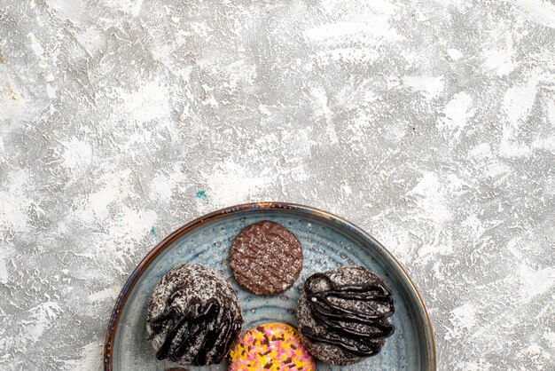 Top view of delicious chocolate balls cakes with cookies on a white surface