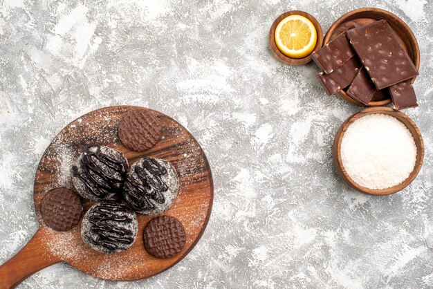 Top view of delicious chocolate balls cakes with cookies on a white surface