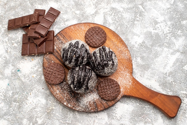 Top view of delicious chocolate balls cakes with cookies on a white surface