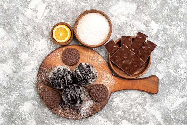 Foto gratuita vista dall'alto di deliziose torte di palline di cioccolato con i biscotti sulla superficie bianca