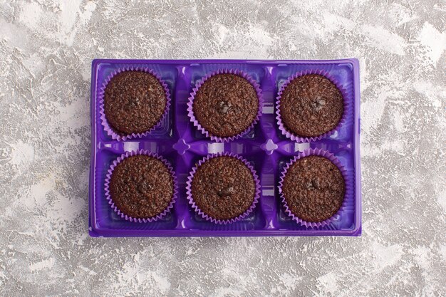 明るい背景に紫色のパッケージ内のおいしいチョコレートブラウニーのトップビュー甘い焼き生地チョコレート