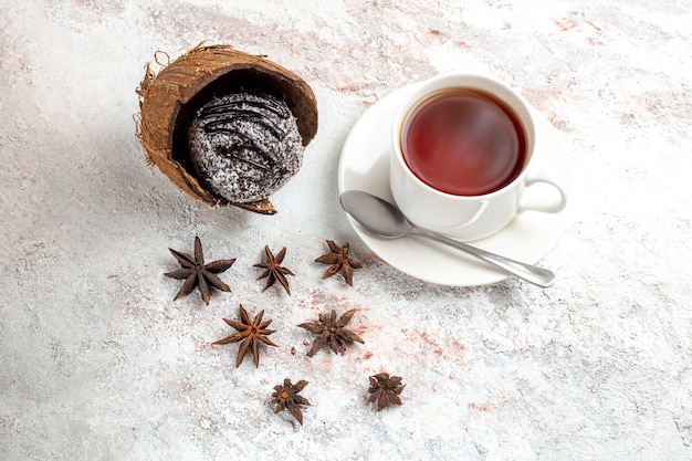 Top view delicious chocolate cake with cup of tea on the light white surface chocolate cake biscuit sweet cookie tea