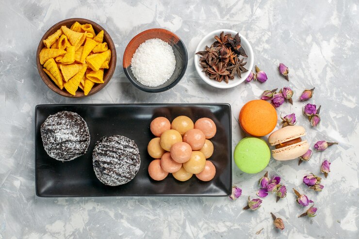 Free Photo top view delicious chocolate cakes with crackers and macarons on light-white surface biscuit bake cake sweet sugar cookie