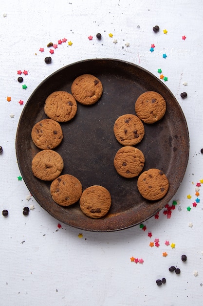 Top view delicious chocolate cookies inside brown round plate on the white background cookie biscuit sweet tea