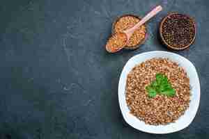 Free photo top view delicious cooked buckwheat inside plate on dark grey space