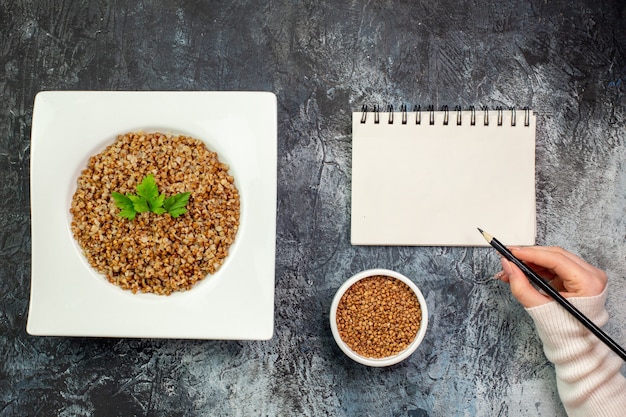 Free photo top view delicious cooked buckwheat inside plate on the light-grey background calorie meal color photo dish bean food