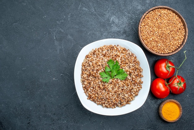 Free photo top view delicious cooked buckwheat with fresh tomatoes on grey space