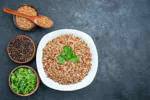 Free photo top view delicious cooked buckwheat with greens on grey space