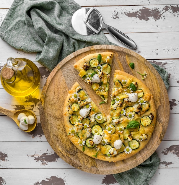 Top view of delicious cooked pizza with chamomile flowers and oil