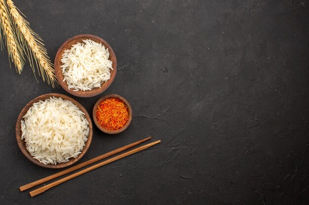 Вид сверху вкусного вареного риса, простая вкусная еда внутри тарелки на темном пространстве
