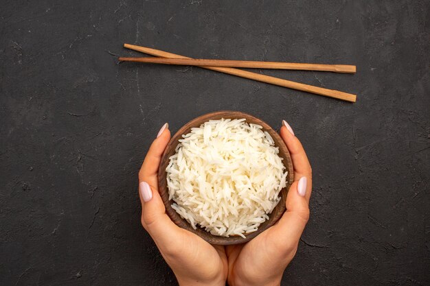 Top view delicious cooked rice plain tasty meal inside plate on dark space