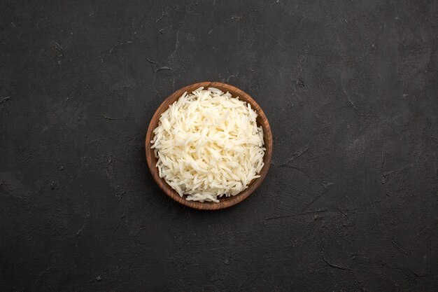 Top view delicious cooked rice plain tasty rice inside brown plate on a dark space