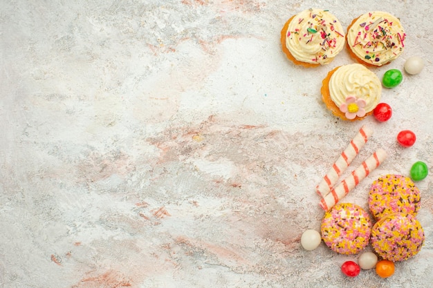 無料写真 上面図白い表面のケーキビスケットクッキーパイの色にカラフルなキャンディーとおいしいクッキーケーキ