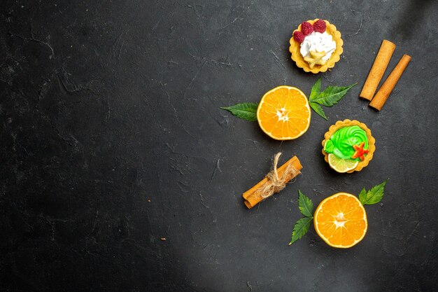 어두운 배경에 잎이 있는 맛있는 쿠키 계피 라임과 반 커 오렌지의 상위 뷰