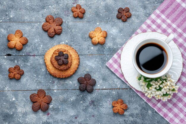 Вид сверху вкусного сладкого печенья с чашкой кофе серое, сладкое печенье сахарное печенье