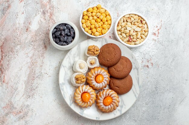 Vista dall'alto deliziosi biscotti con caramelle e noci su sfondo bianco biscotto torta dolce biscotto dado