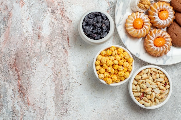 Top view delicious cookies with candies and nuts on white background cake cookie biscuit sweet sugar tea