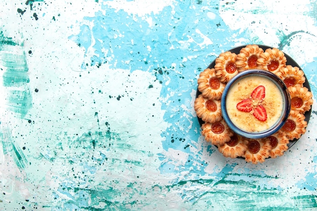 Top view delicious cookies with jam and strawberry dessert on light blue background cookie sugar sweet biscuit cake dessert