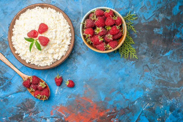 Вид сверху вкусный творог со свежей малиной на синем фоне цветная ягода фото завтрак фрукты