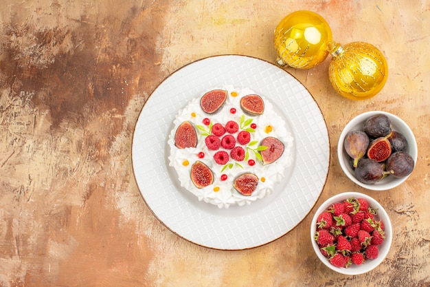 Free photo top view delicious cream cake with fruits and toys