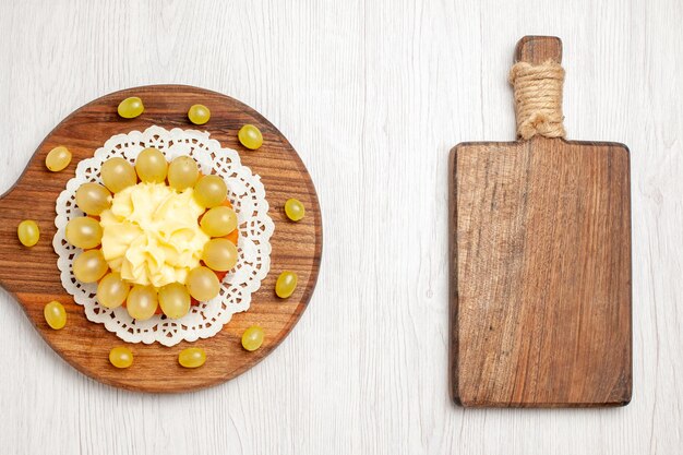 Free photo top view delicious cream cake with green grapes on white desk fruit dessert cake biscuit pie cookie