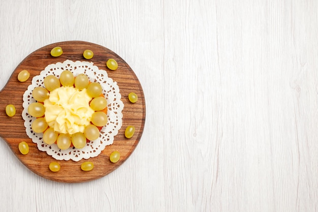 Top view delicious cream cake with green grapes on a white desk fruit dessert cake biscuit pie