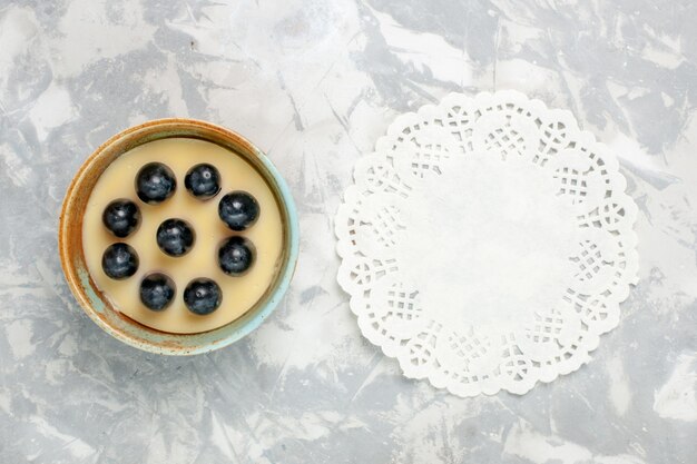 Top view delicious cream dessert with grapes on top inside little pot on light white surface ice-cream dessert cream sweet