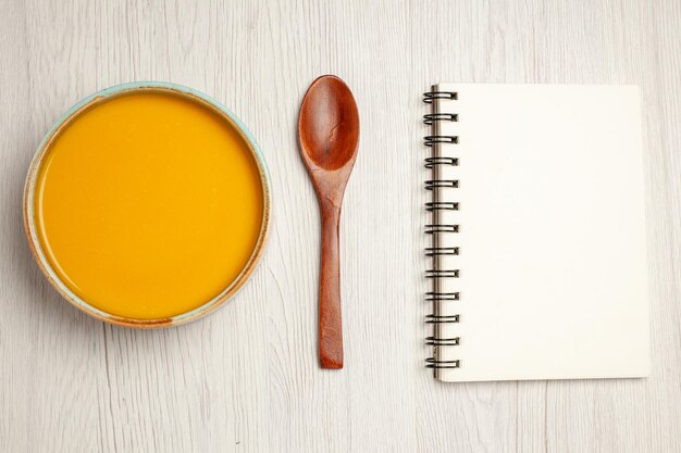トップビュー美味しいクリームスープ黄色いスープに白い机のスープソースミールクリームディナーディッシュ